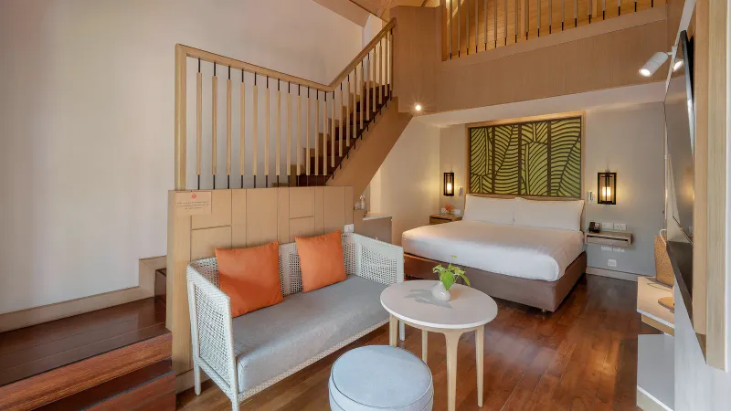 Amari Koh Samui family suite with a mezzanine bedroom above a sofa lounge and timber floor