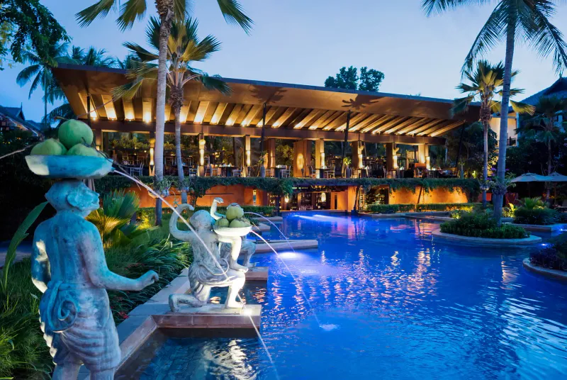 Anantara Bophut's main building and pool lit at dusk