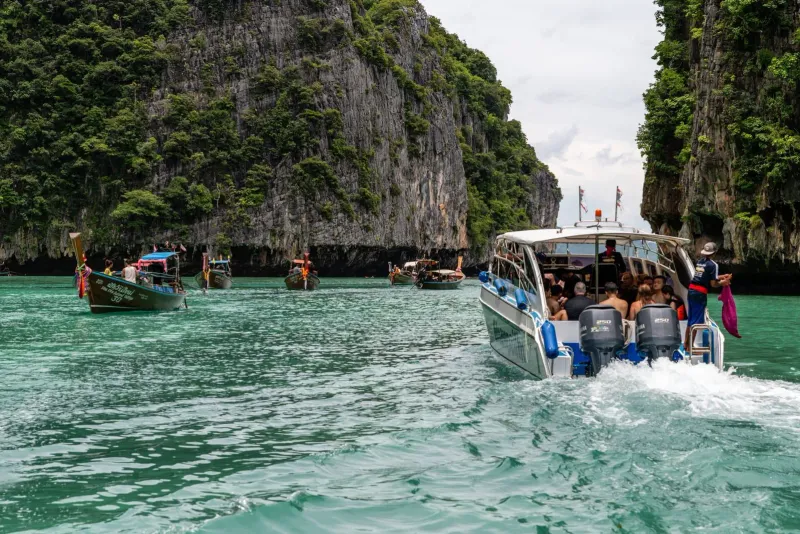 Speedboat passing limestone island scenery on a Gulf of Thailand day trip