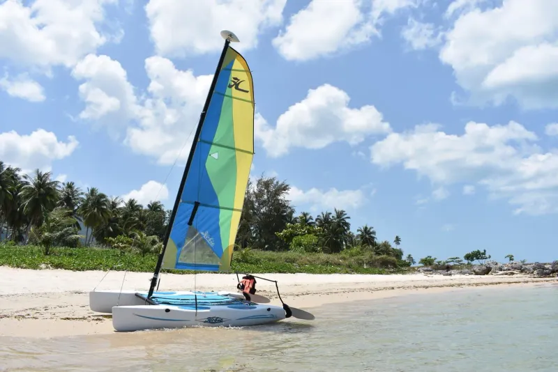 A small catamaran resting on the sand along Koh Samui's northwest coast