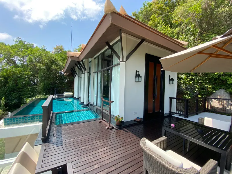 Banyan Tree Samui hillside villa with a timber deck, tiled private pool and forest behind