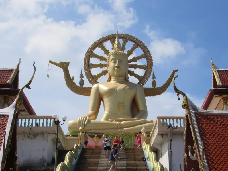 Majestic golden Buddha statue at Wat Phra Yai temple, Thailand, showcasing vibrant cultural architecture