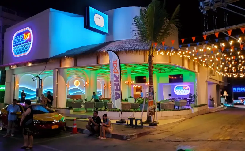 Taxi parked on a lit Chaweng Beach road at night near a beach club on Koh Samui