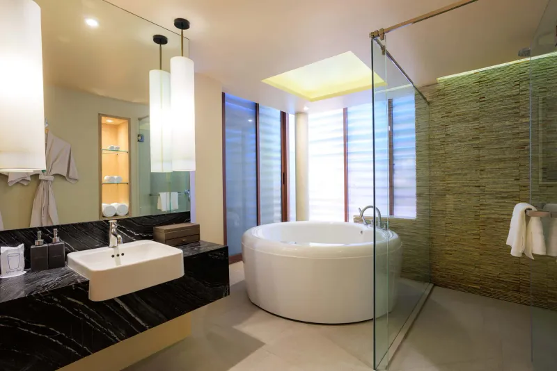 Zimmerbad mit Marmorwaschbecken, runder Badewanne und Glasdusche im Chaweng Regent Beach Resort