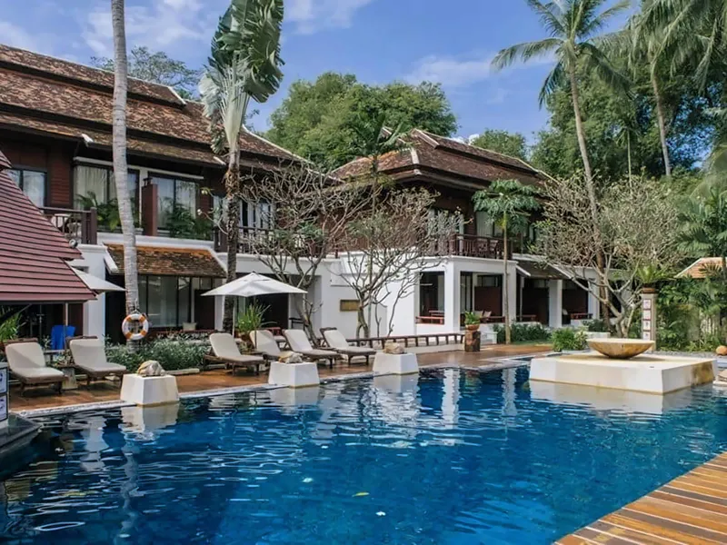 Pool mit Sonnenliegen vor zweistöckigen Gästehäusern aus Holz im Chaweng Regent Beach Resort