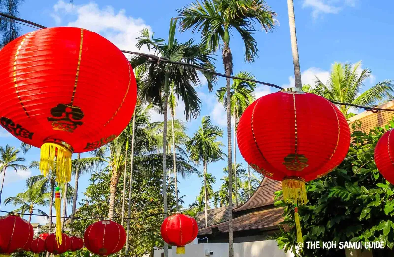 Rows of red Chinese lanterns with gold tassels strung between palm trees for Chinese New Year on Koh Samui