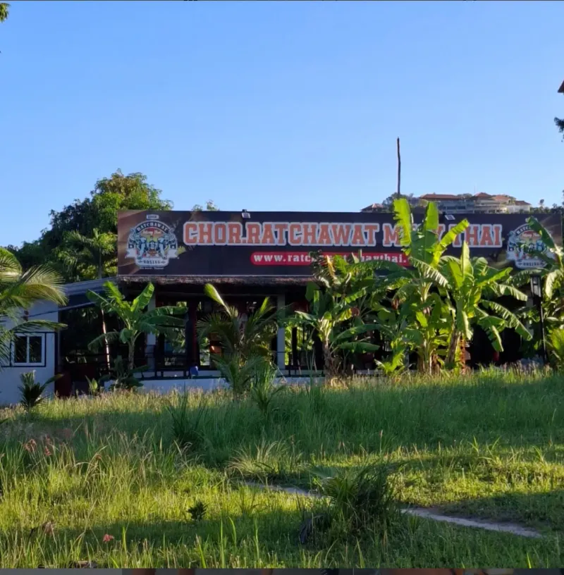 The Chor Ratchawat signboard above a grassy plot with banana plants