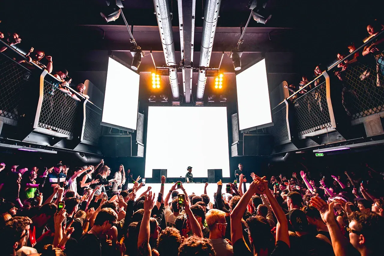 Crowd with hands up in front of a club stage