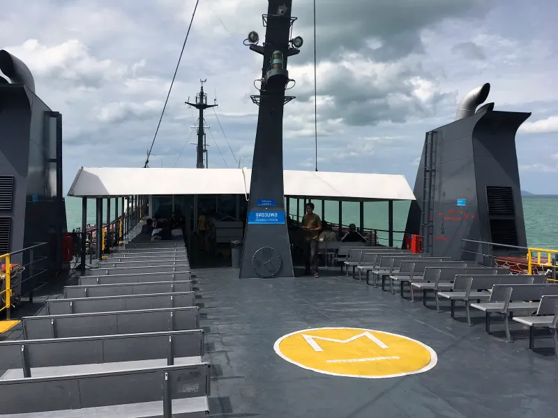 Upper deck of a conventional ferry with benches and open sea at Donsak crossing