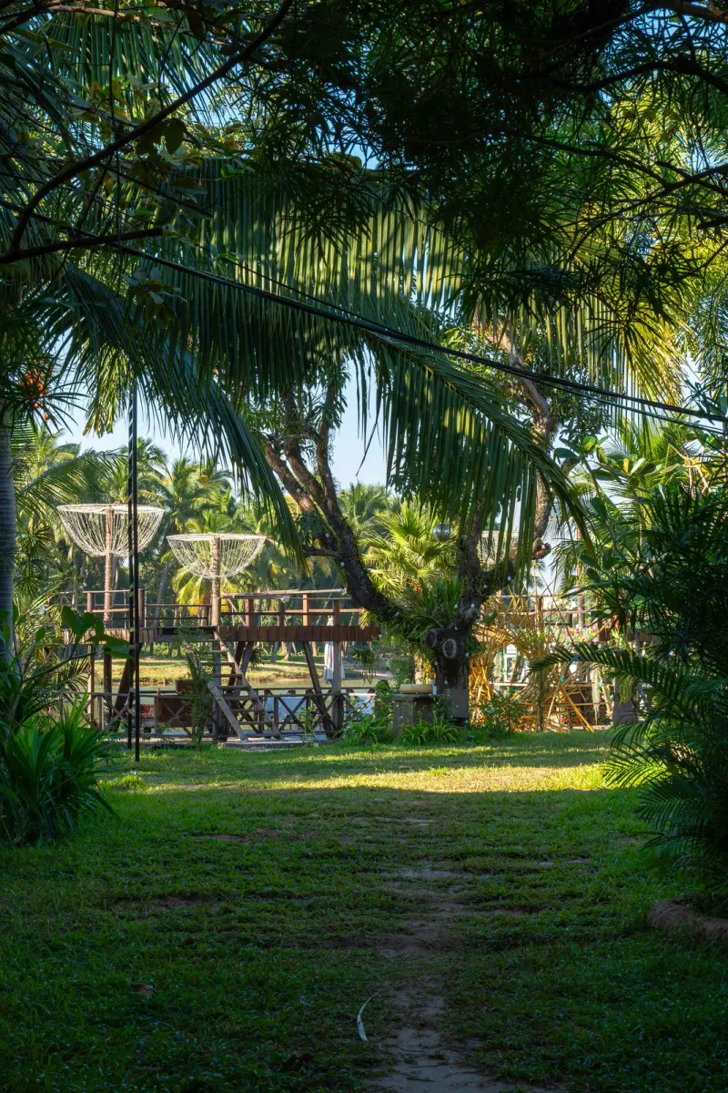 A treehouse-style structure amid lush tropical greenery, generic illustration of the garden setting art parks like Dusit Dhewa occupy