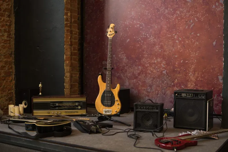 E-Gitarren und Akustikgitarren auf Ständern neben Lautsprecherboxen, die Art von Warenbestand und PA-Technik, die ein Instrumentengeschäft führt
