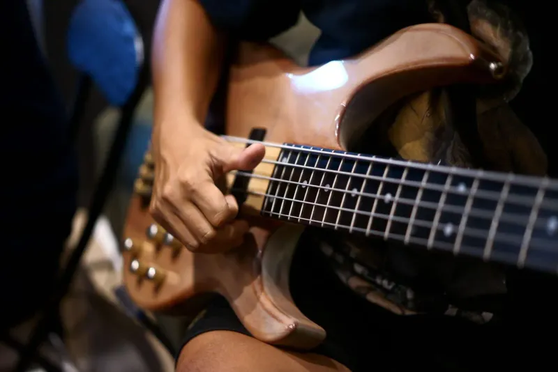 Nahaufnahme einer Musikerhand beim Spielen einer E-Bassgitarre