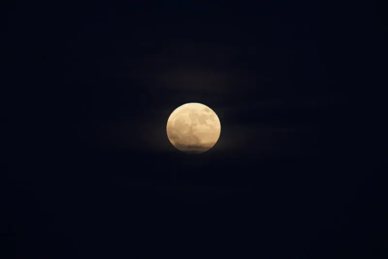 A bright full moon in a clear night sky, the lunar event that sets Koh Phangan's monthly Full Moon Party date