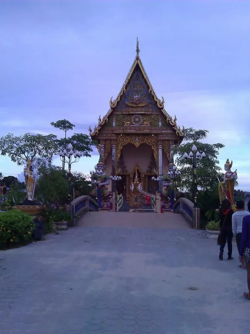 A red-and-gold temple pavilion at dusk on Koh Samui