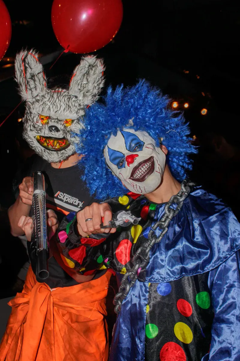 Person in a clown mask and wig at a Halloween party