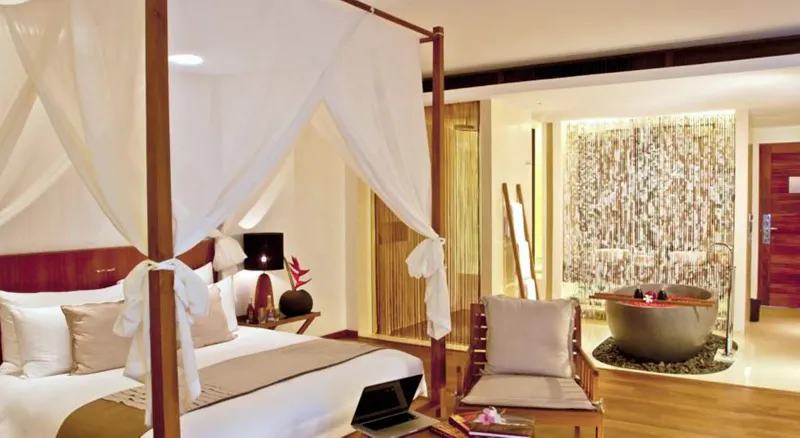 Room with a white four-poster bed, wooden floor and a stone bathtub at Hansar Samui
