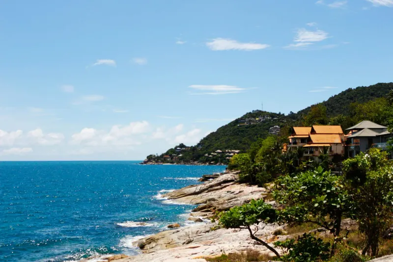 Rocky headland with hillside villas and blue sea on the Koh Samui coast near Chaweng