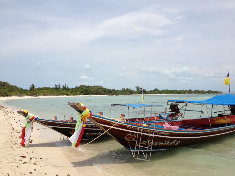 Longtail boats pulled up on the beach at Koh Madsum