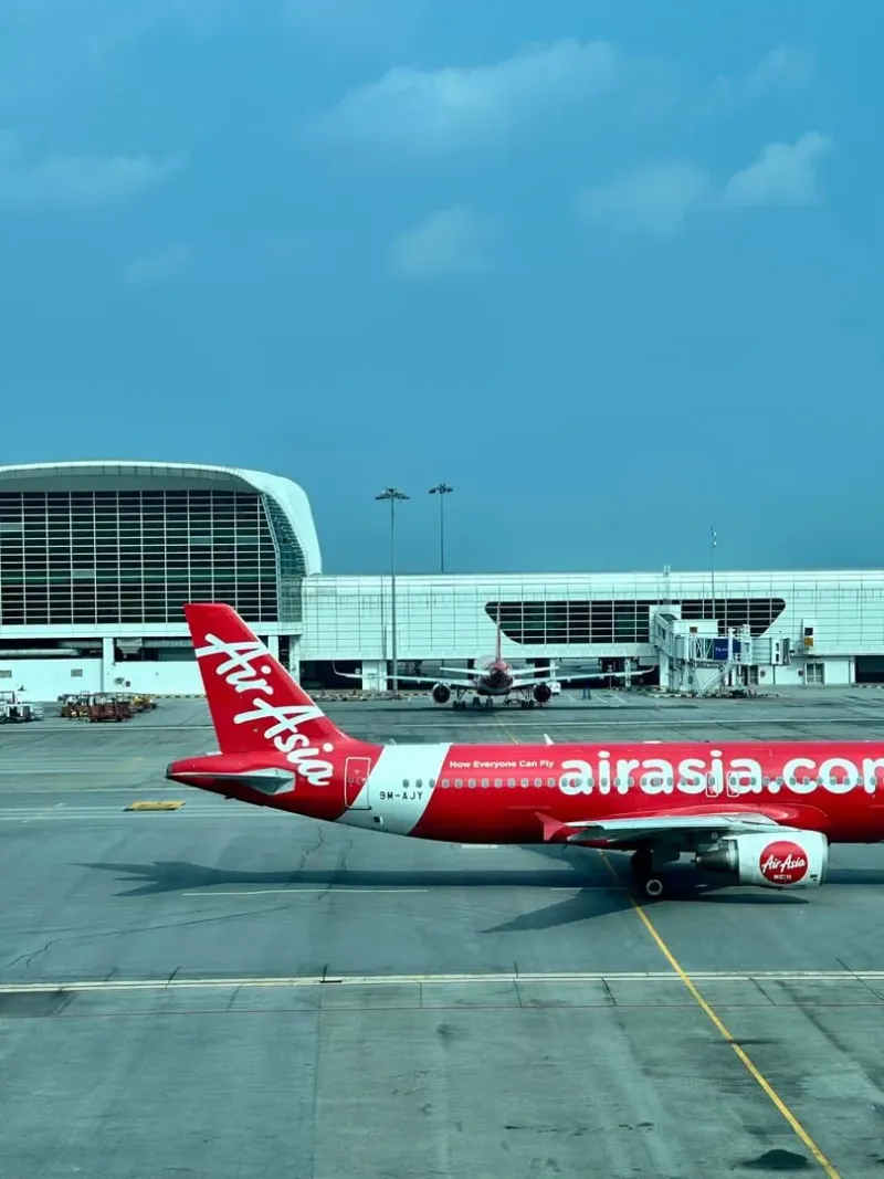 Aereo di linea regionale che rulla davanti a un terminal moderno che serve gli arrivi a Koh Samui