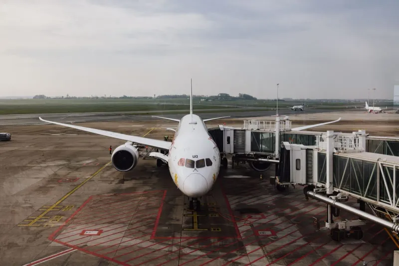 Passenger jet parked at an airport gate under a cloudy sky, as used by Bangkok Airways at Samui