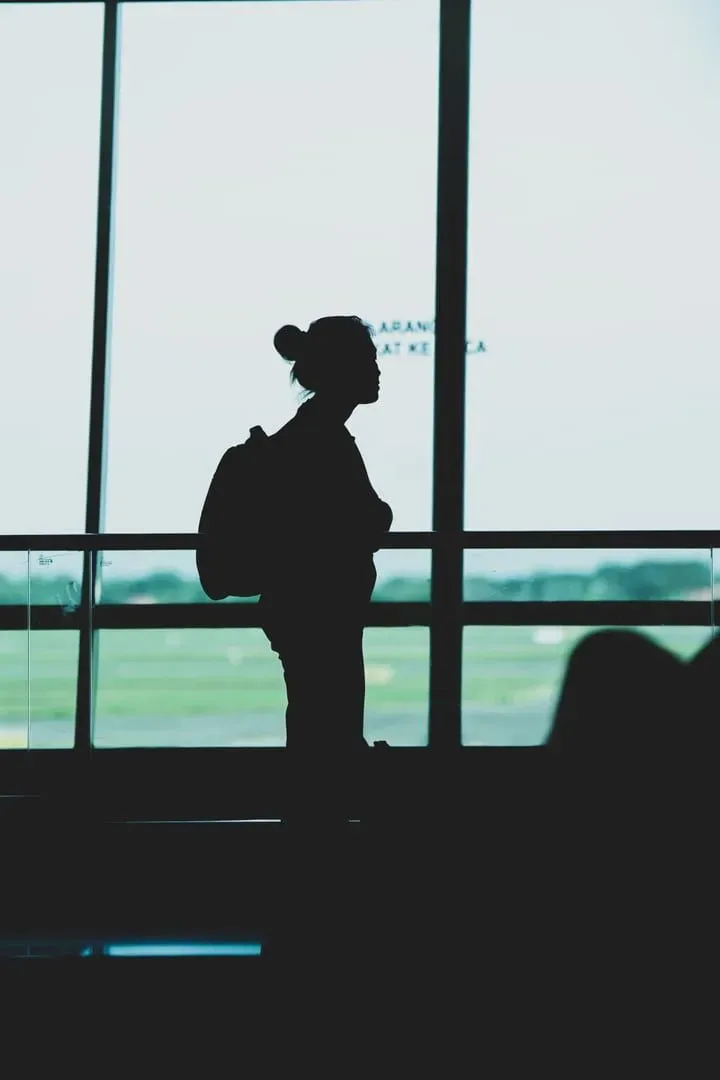 Traveler with a backpack standing in an airport terminal, waiting for onward transport on Koh Samui