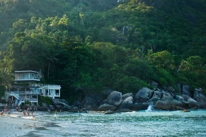 Lush green hillside above a tropical beach on Koh Samui after monsoon rain has fed the island's waterfalls