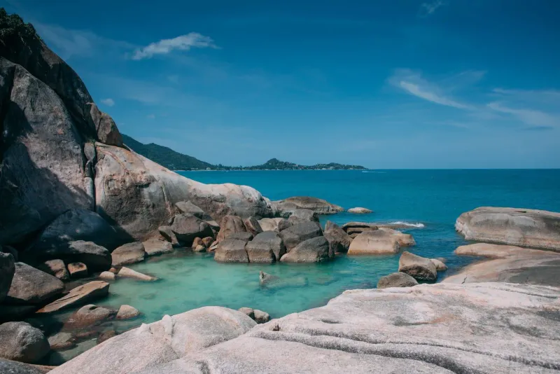 A tranquil rocky lagoon on Koh Samui with turquoise water and dramatic boulders