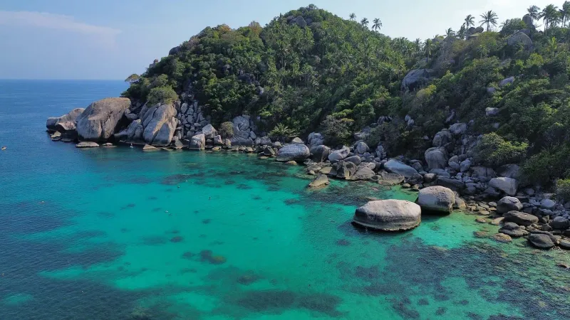 Tropical Shark Bay cove on Koh Tao with lush greenery, reachable by ferry from Koh Samui