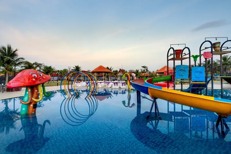 Colorful resort waterpark with slides and palm trees reflected in the pool in Koh Samui