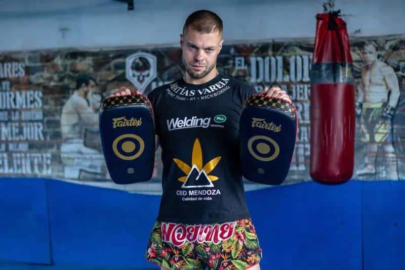 Kickboxer holding focus pads in a Koh Samui gym, illustrating Muay Thai pad work at a Lamai fight gym