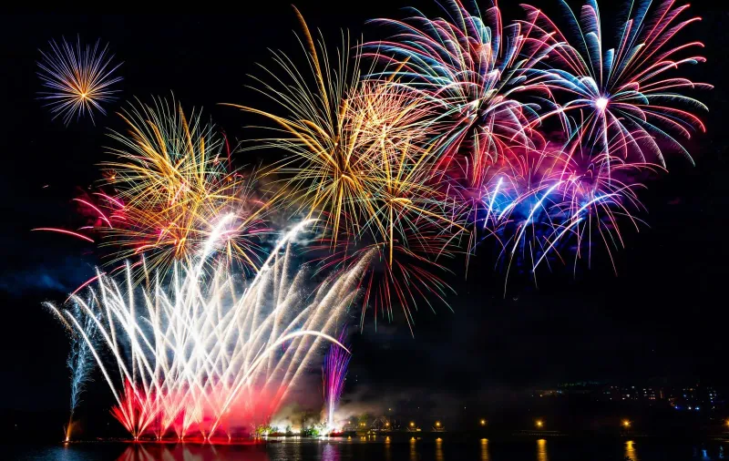 Fireworks reflected over calm water at a tranquil bay near Koh Samui during the festive season