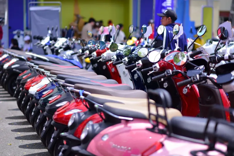 Row of colourful scooters displayed outdoors at a Koh Samui rental shop