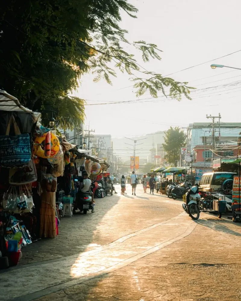 Bustling Thai street market at sunset with local food vendors, a budget-friendly way to eat on Koh Samui