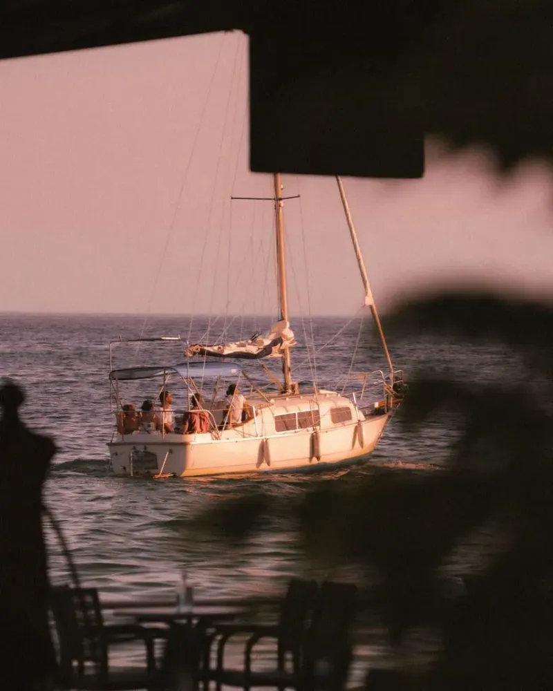 Sunset cruise boat crossing calm water off Koh Samui with passengers on deck