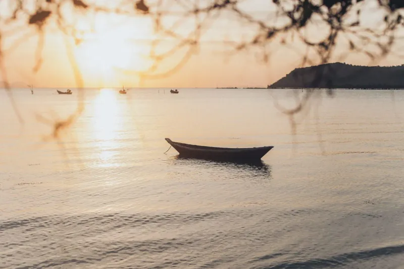 Boat resting on still water at sunset near Lipa Noi Pier on Koh Samui