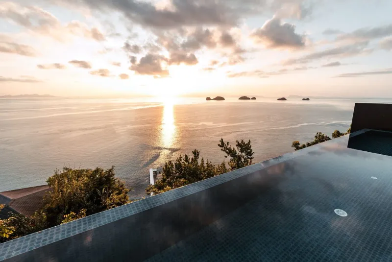 Infinity pool overlooking the Gulf of Thailand at sunset, typical of Taling Ngam's hillside resorts