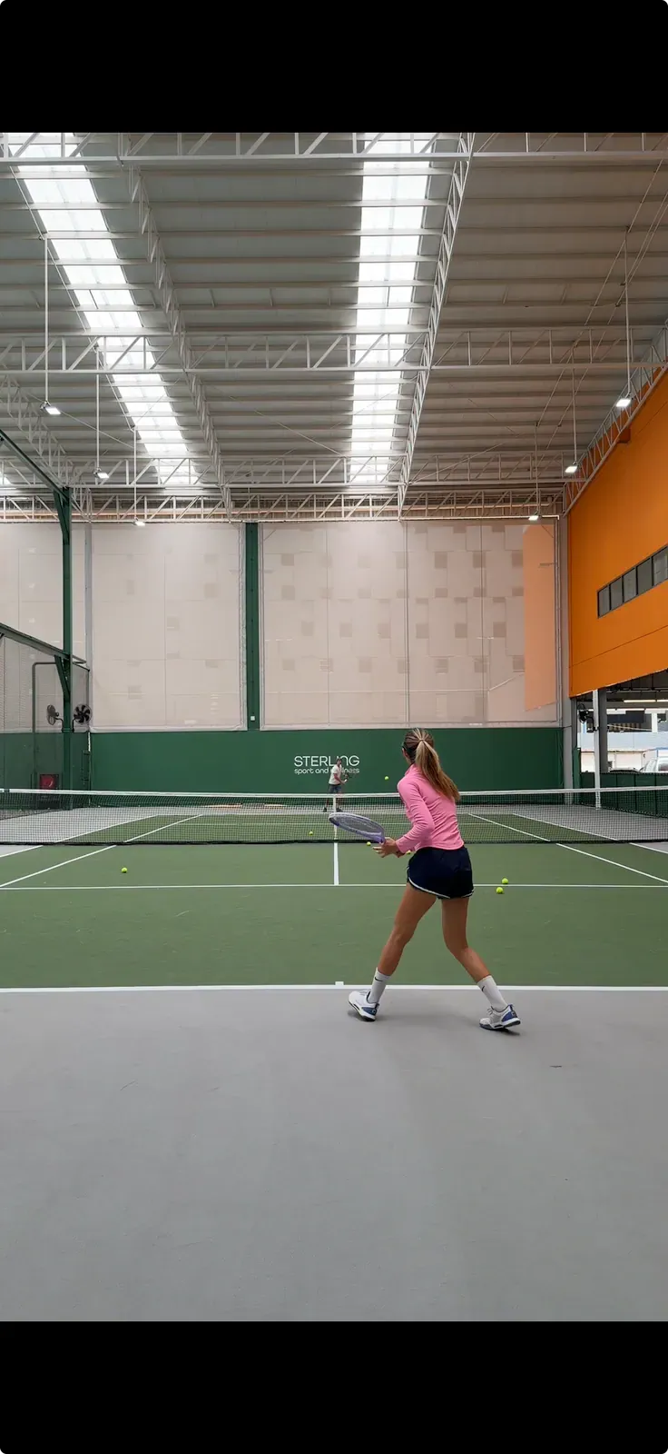 A tennis player hitting a forehand on a covered hard court