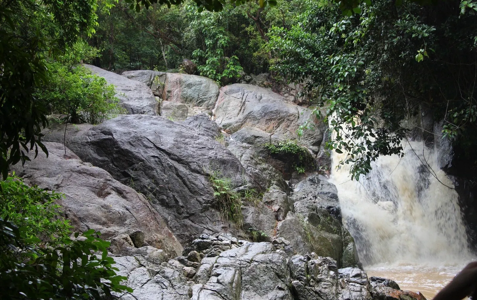 Moss-covered boulders along Lat Wanon Waterfall's cascade