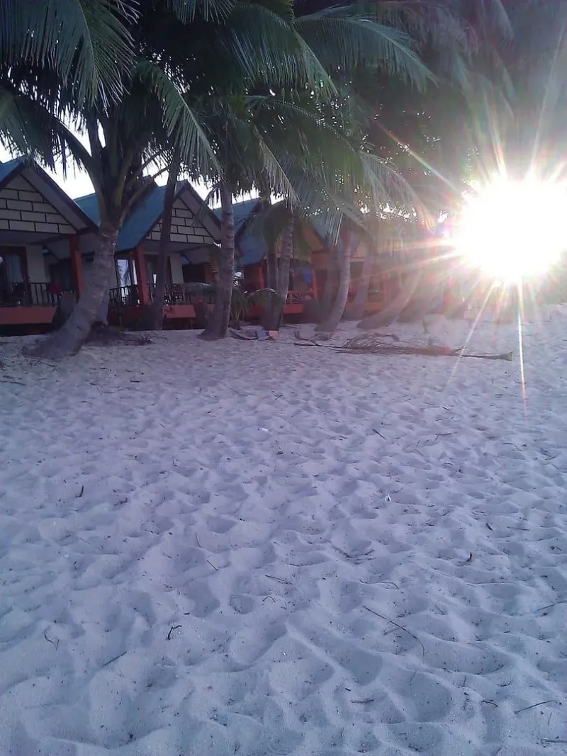 Sunrise over beachfront bungalows and palm trees near Maenam Viewpoint, Koh Samui