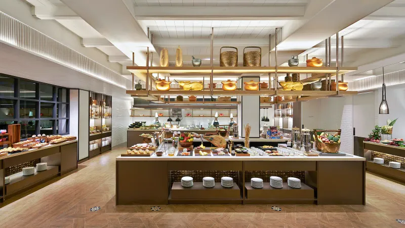 Breakfast buffet at Melia Koh Samui with a central food island, open kitchen and chefs at work