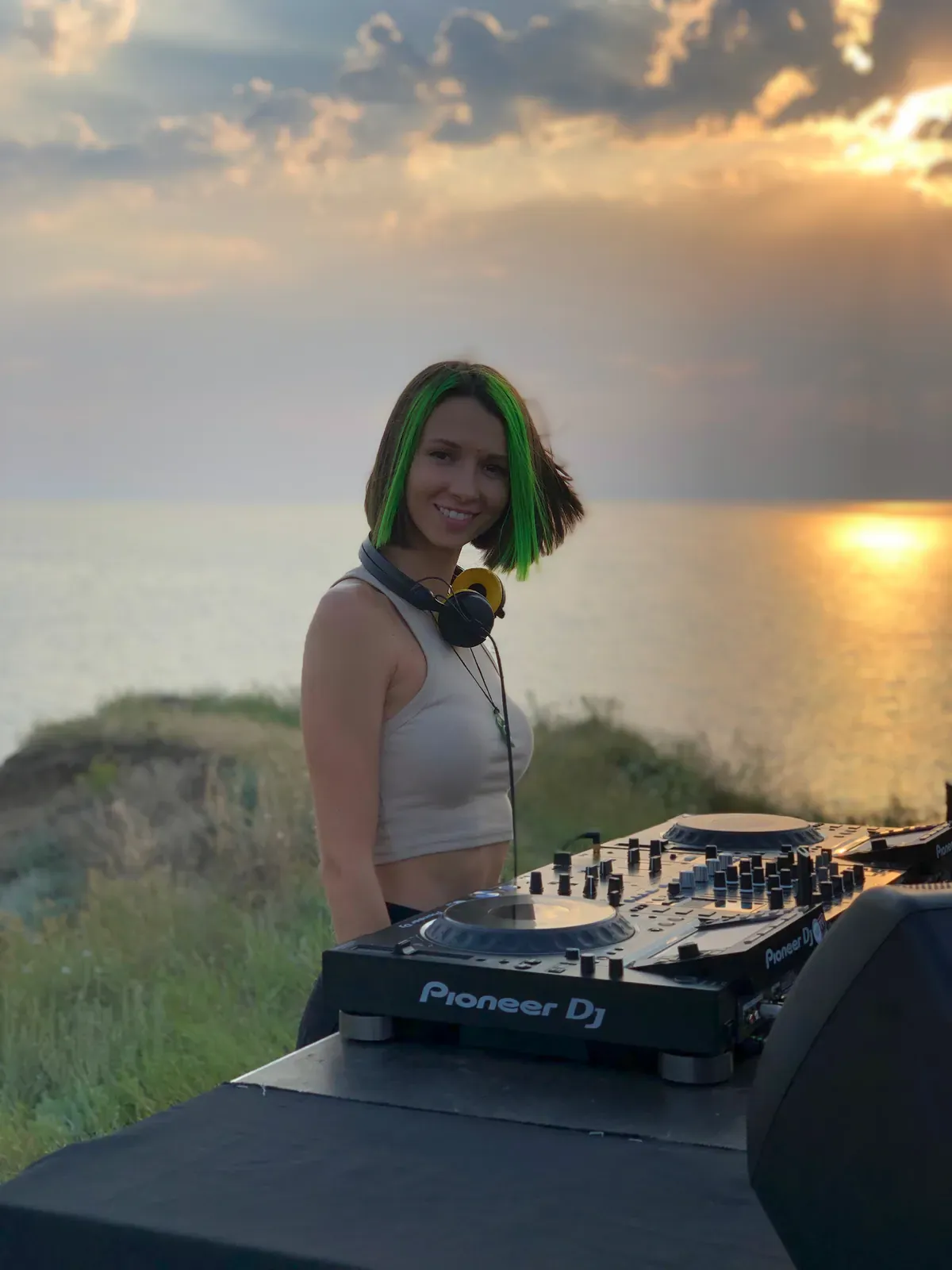DJ Miss Monique at the decks outdoors at sunset