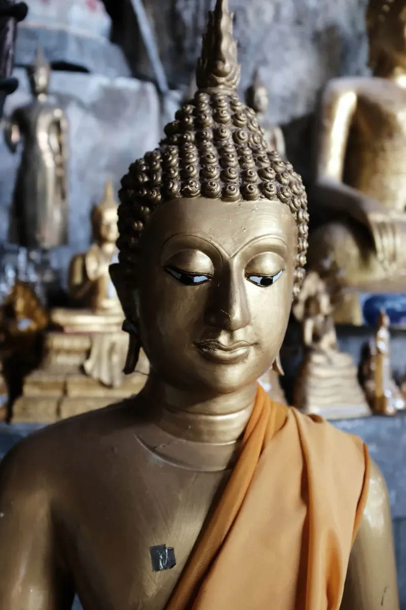 Close-up of a gilded Buddha statue in a cave shrine