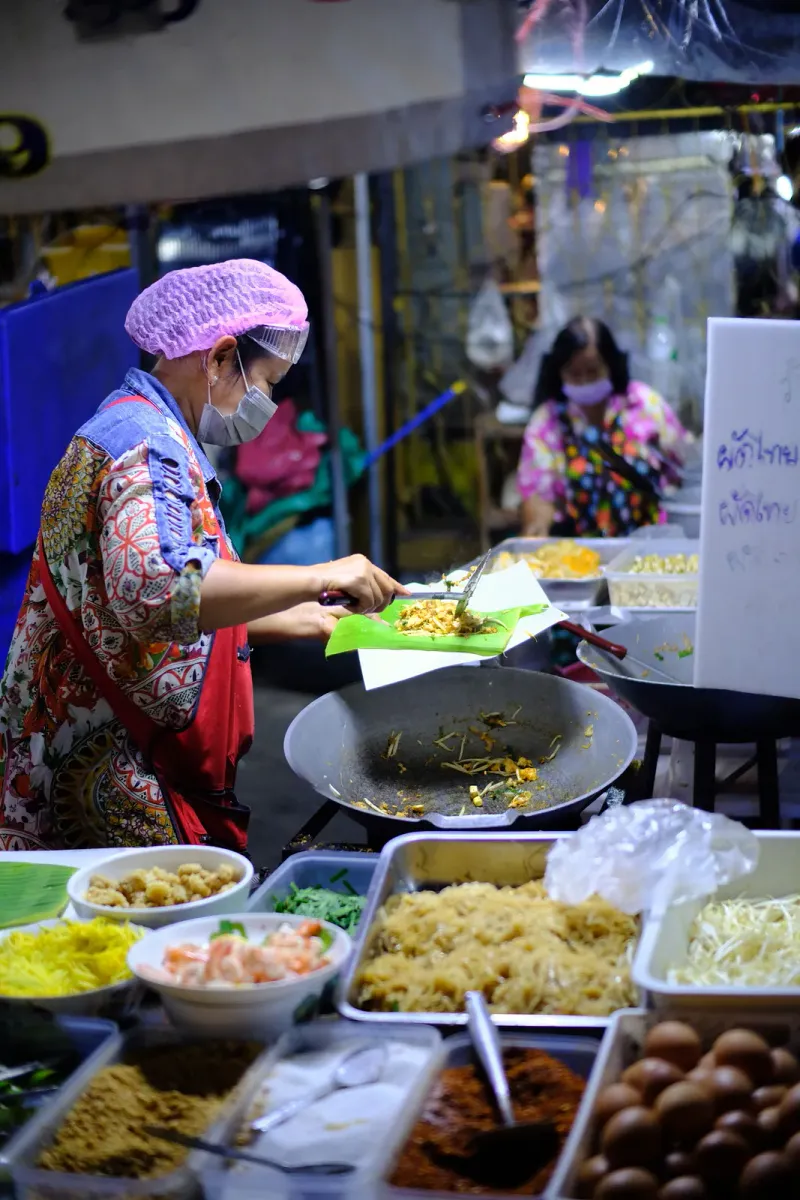 A street vendor cooking noodles at a food stall