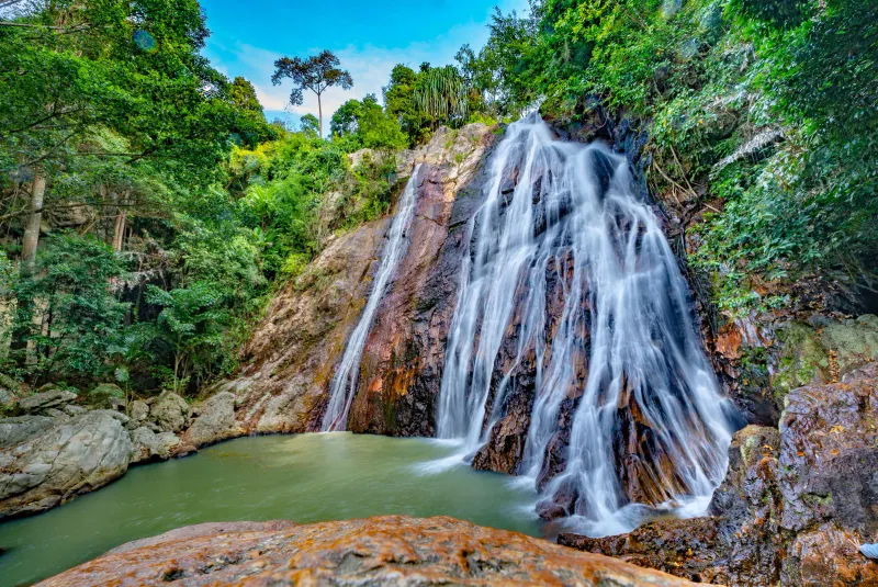 The purple-tinted rock face of Na Muang 1 waterfall, Koh Samui