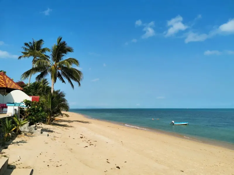A single boat moored off a quiet local beach