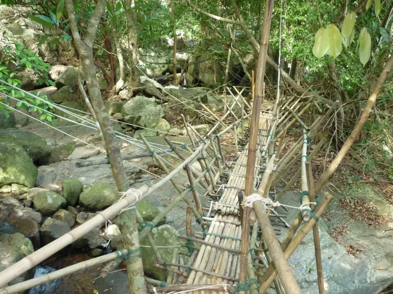 Na Muang 1 waterfall pouring over purple-tinted rock into a swimming pool on Koh Samui, Thailand