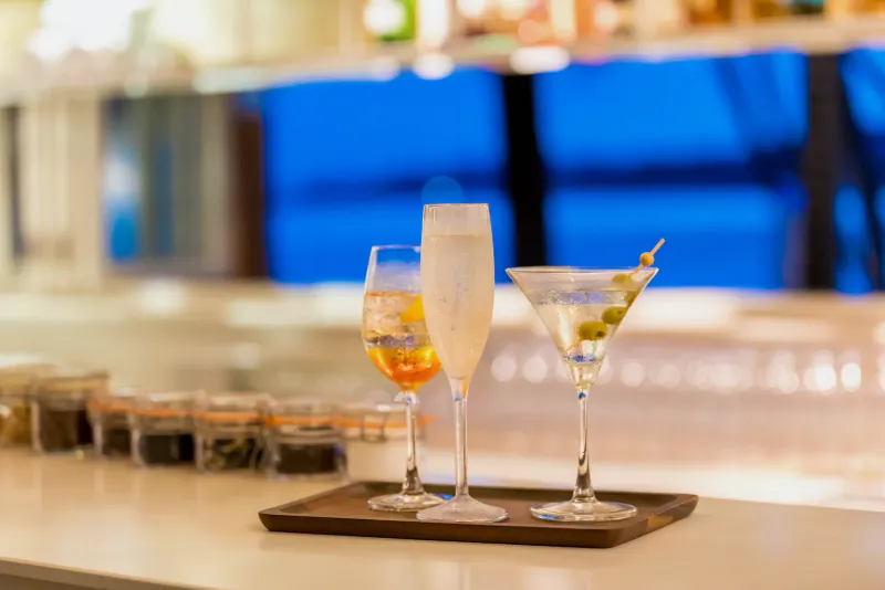Three cocktails on a wooden tray at a bar at Outrigger Koh Samui Beach Resort