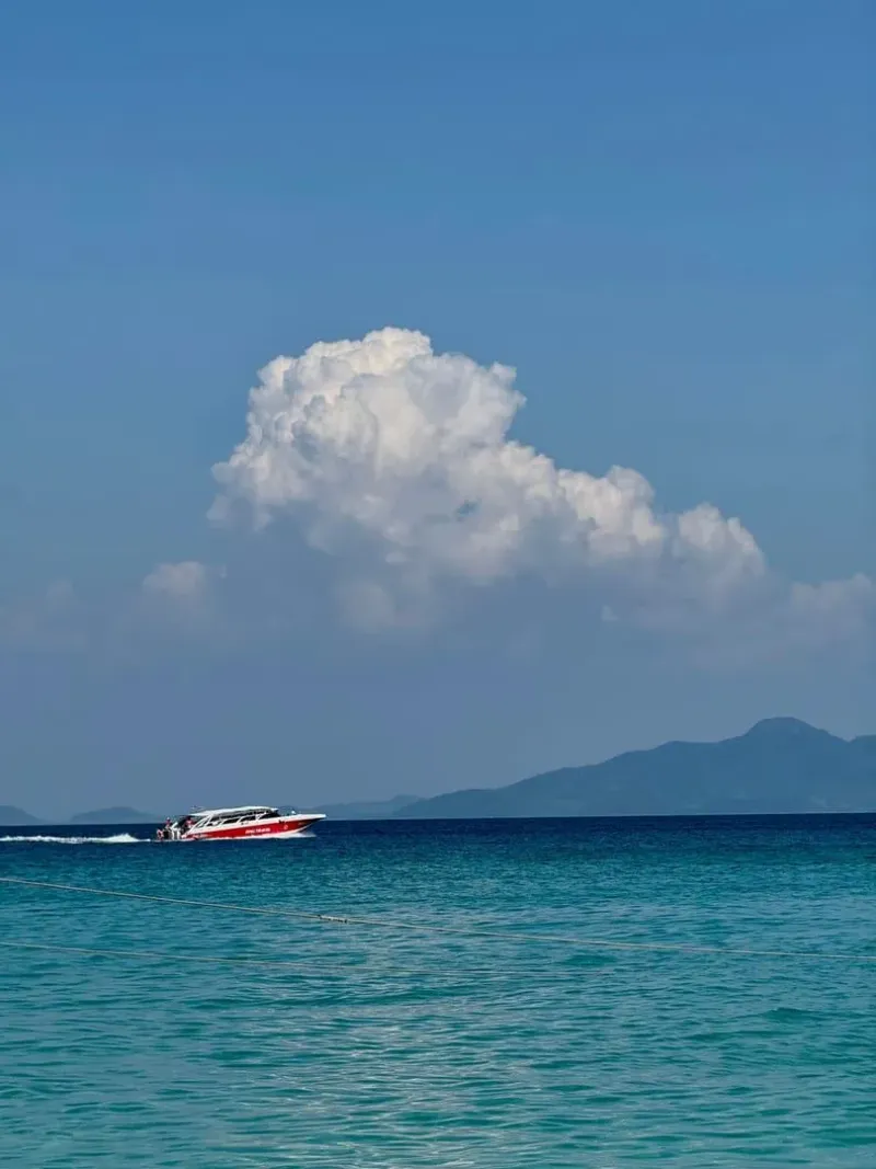 Speedboat cruising across turquoise water under a bright blue sky