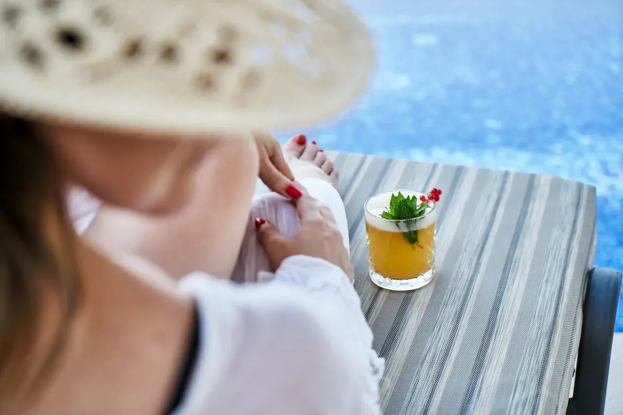 Cocktail on a table beside a swimming pool