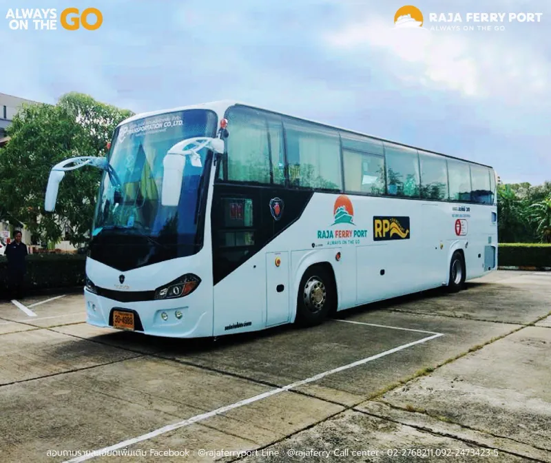 White coach with Raja Ferry Port branding parked in a lot under a blue sky